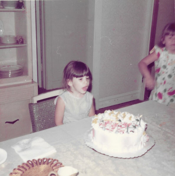 Child sitting in front of their cake.