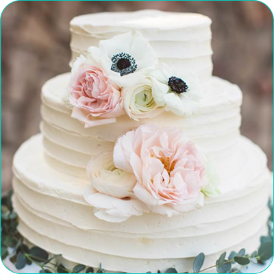 Three tier white wedding cake with flowers