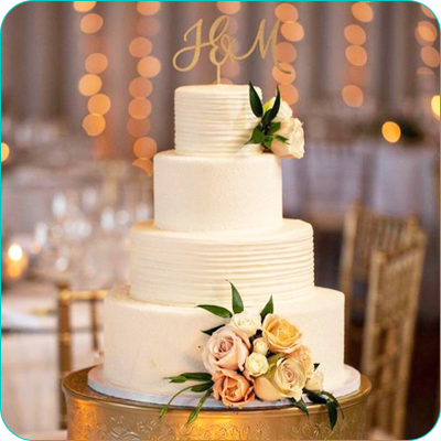 Four tier white wedding cake with flower accents