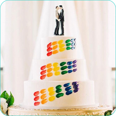 Three tier wedding cake with rainbow accents and same-sex couple topper